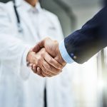 Cropped shot of a doctor shaking hands with a businessman